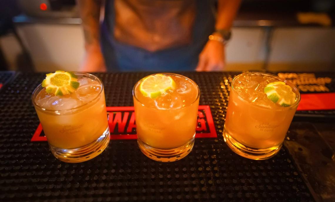 Close up of three lime garnished cocktails on a bar mat