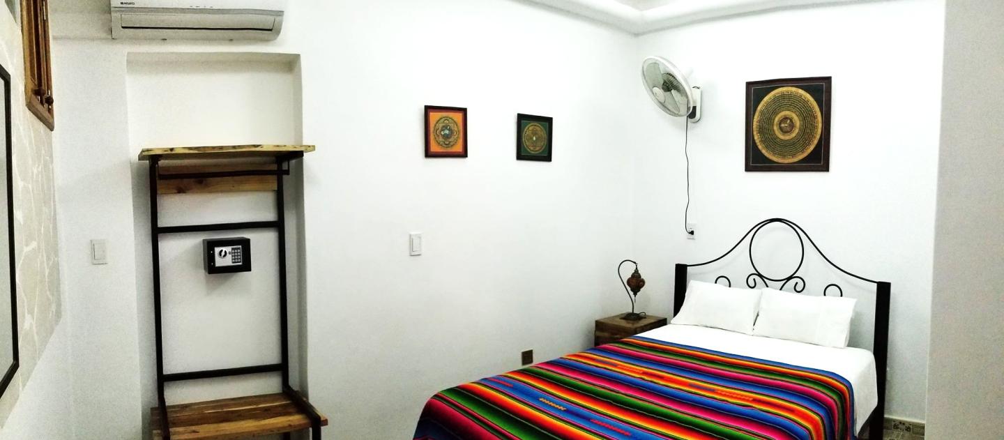 Colorfully decorated room with striped bedspread at a casa particular in Cuba