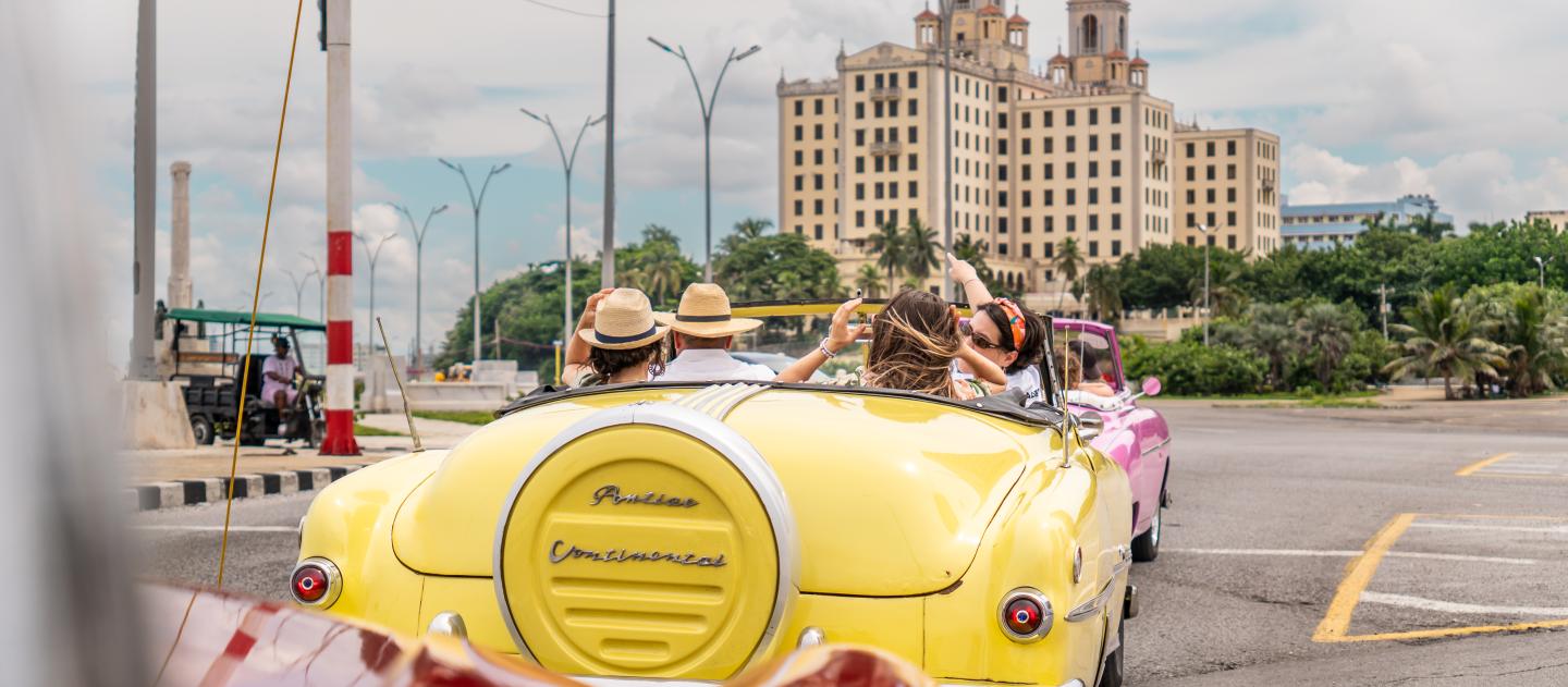 Cruising toward Havana's Hotel Nacional in a yellow convertible