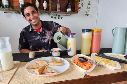 Host serving a colorful Cuban breakfast spread at Malecon Sunset guesthouse in Havana