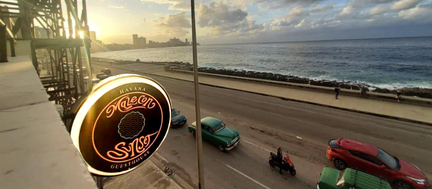 Sunset view of Havana's Malecon coastline with classic cars from Malecon Sunset guesthouse